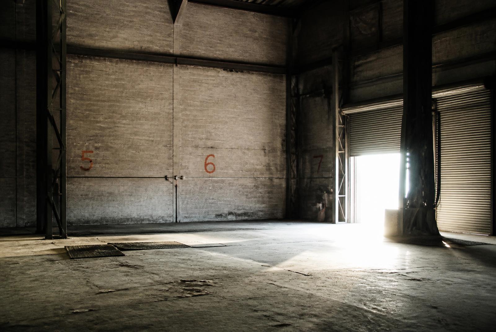 Raw industrial warehouse interior with stencilled orange numbers